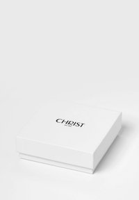 Weißer rechteckiger Karton mit glatter Oberfläche, auf dem das Wort "CHRIST" in fetten schwarzen Buchstaben und in kleineren Schriftzug "seit 1863" zu sehen ist.