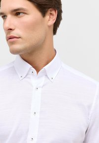 Witte button-up shirt van een textuurstof, met een klassieke kraag en zwarte accentknopen. Slank passende ontwerp.