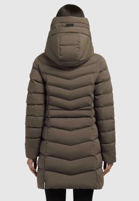 Cappotto imbottito marrone con un motivo a zigzag, colletto alto e cappuccio. Presenta cuciture verticali e un taglio dritto, che arriva a metà coscia.