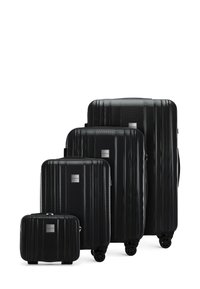 Vier zwarte harde koffers in verschillende maten. Kenmerken een ribbeltextuur, duurzaam plastic materiaal en soepel rollende wielen.