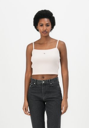 Rosa ribbet cropped topp med tynne stropper og en liten logo-detall foran, kombinert med høyt liv svarte jeans.