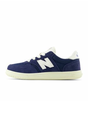 Blauer und weißer New Balance Sneaker mit Wildlederoberteil, weißen Schnürsenkeln und weißer Sohle in Seitenansicht nach links.