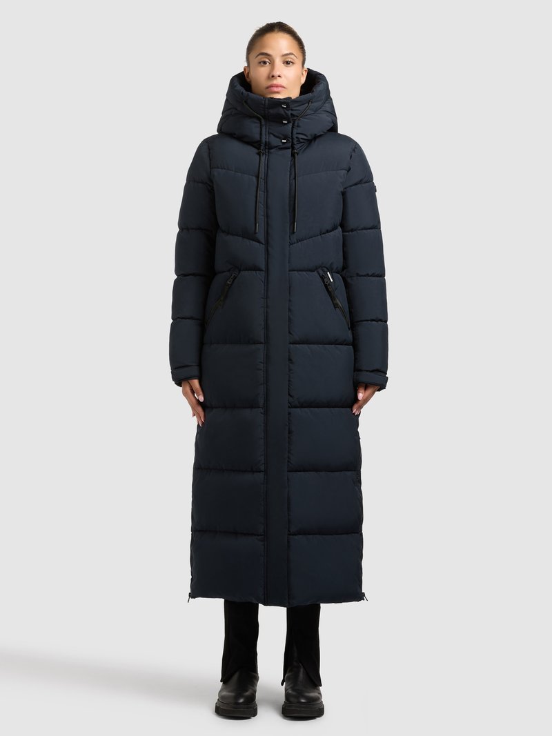 Tengerészkék, hosszú, bélelt kabát kapucnival, elöl cipzárral, cipzáras oldalzsebekkel és rugalmas, állítható kötőkkel a kapucninál.