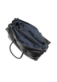Schwarze Lederhandtasche mit einem Reißverschluss, ausgestattet mit einem inneren marineblauen Futter und zwei Reißverschlusstaschen. Weiche Textur, strukturierte Form und kurze Griffe.