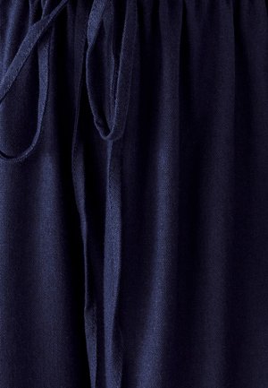 Tumedav sinine kangas pehme tekstuuriga, millel on kokku volditud vöökoht ja seotud paeladetail. Sile, kergest materjalist.