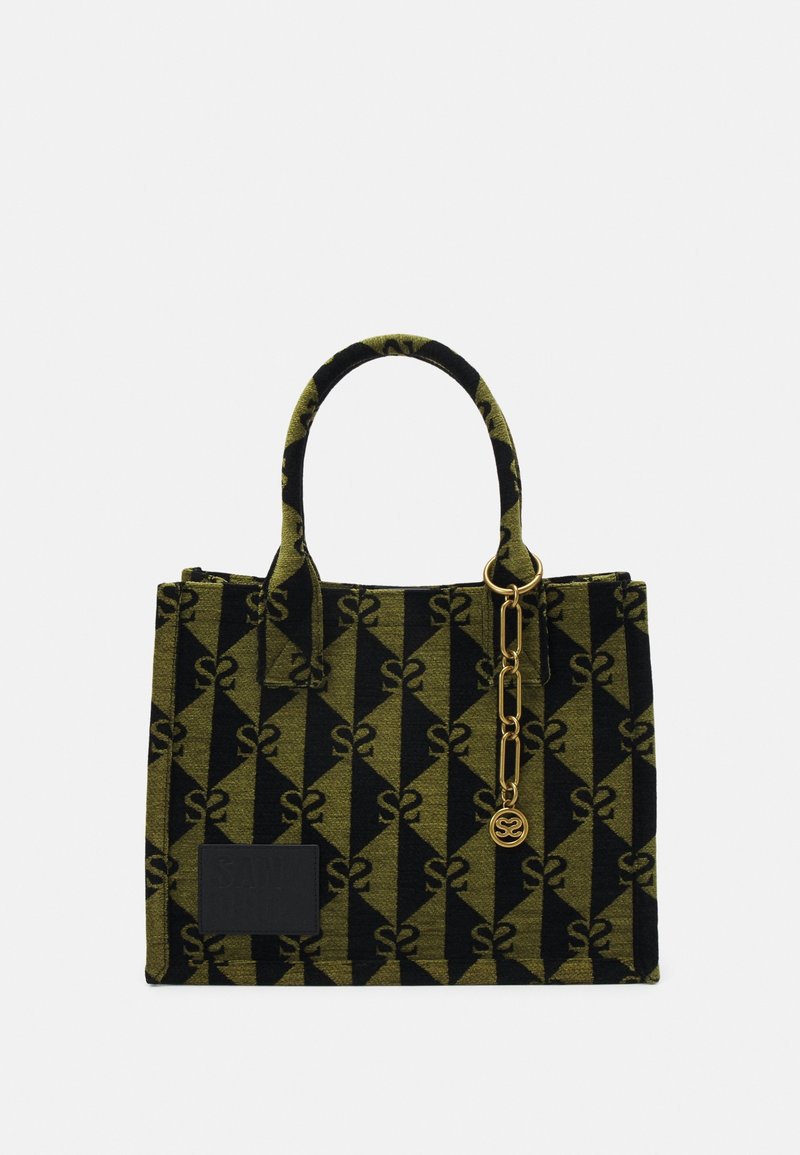 Sac rectangulaire avec motif géométrique noir et vert olive, deux poignées, une chaîne dorée avec un pendentif rond et une petite pièce noire à l'avant.