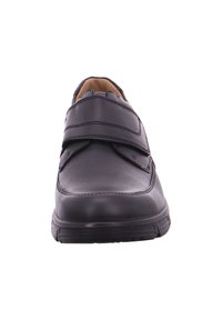 Black leather shoe with a rounded toe, two Velcro straps across the upper, and a rubber sole for grip. Smooth texture with minimal design details.