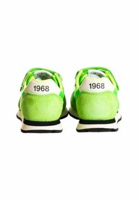 Sneaker in suede verde con dettagli bianchi, caratterizzati dall'anno "1968" sul tallone e una suola in gomma nera. Design arrotondato con colletto imbottito.
