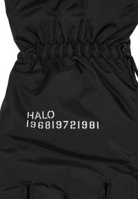 Svart tyg med samlad sömn och vit text: "HALO 196819721981." Fokusera på tygtextur och design detaljer.