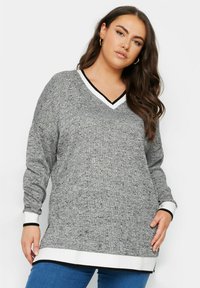 Maglione grigio a maniche lunghe con scollatura a V e un motivo testurizzato, dotato di bordi bianco e nero sul collo e sui polsini, e un orlo dritto.