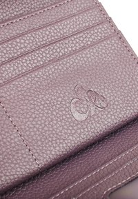 Portafoglio in pelle textured viola con multiple fessure per carte e logo impresso. Finitura liscia con dettagli di cucitura visibili.