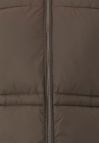 Brun polstret vest med frontlås, med horisontal søm og en glatt, glinsende tekstur. Uten ekstra detaljer.