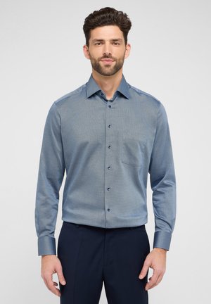 Blaues Hemd mit einem subtilen Muster, langen Ärmeln, einer Brusttasche und dunklen Knöpfen; der Stoff wirkt glatt und leicht.