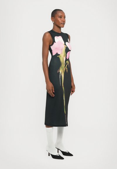 Rochie neagră fără mâneci, cu un imprimeu floral roz mare, până la genunchi, confecționată dintr-un material neted. Purtați cu șosete albe până la glezne și pantofi cu toc negri.
