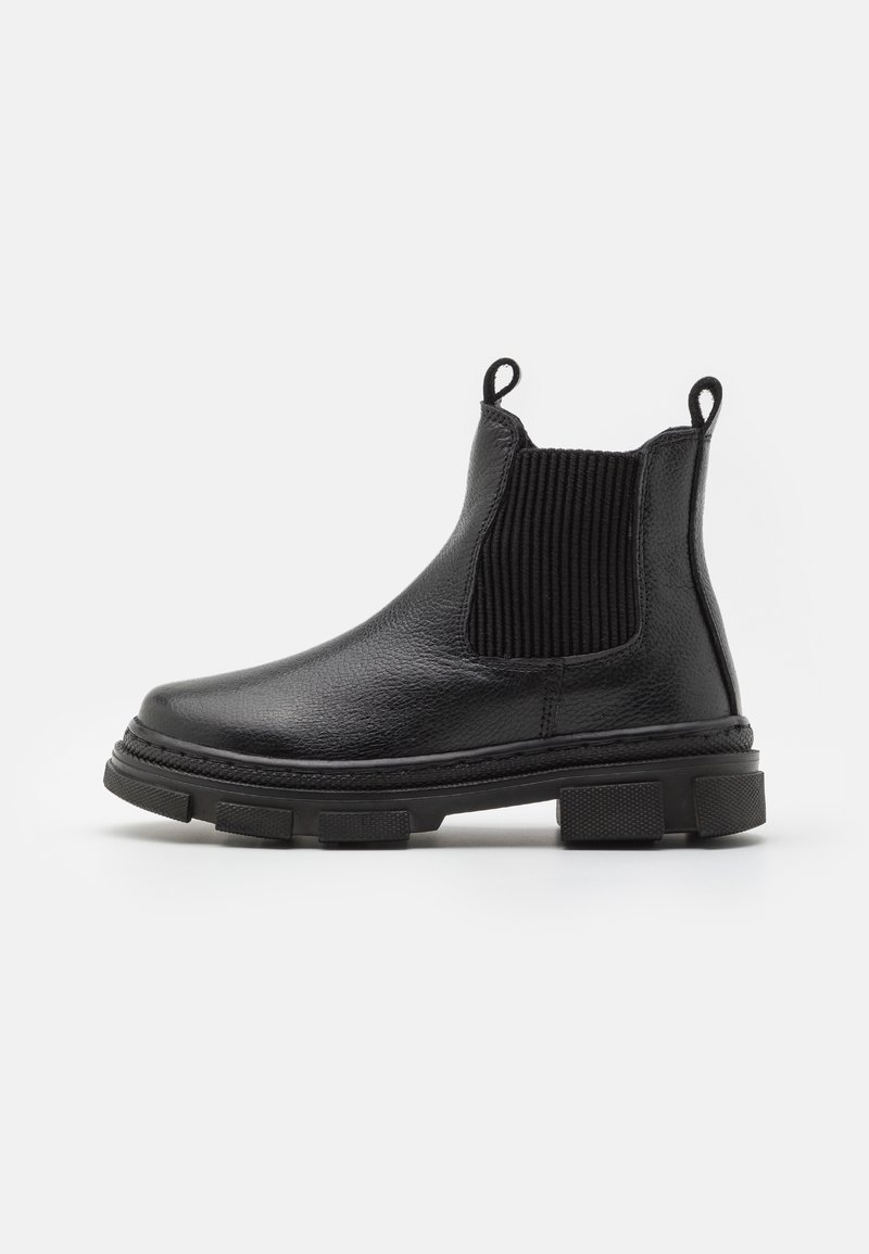 Bottine Chelsea en cuir noir pour cheville avec semelle épaisse, panneaux latéraux élastiques et languettes à l'avant et à l'arrière sur fond blanc.
