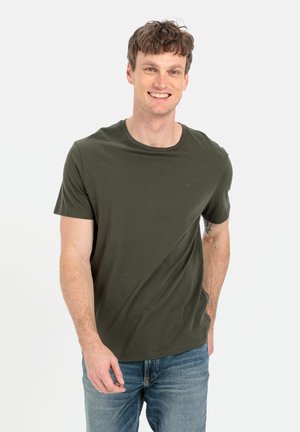 Olivenfarvet bomulds T-shirt med korte ærmer og rund hals, med et diskret logo og en glat tekstur, parret med blå jeans.