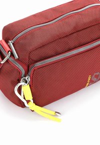 Czerwona torba z teksturowanej tkaniny z dwoma zamkami błyskawicznymi, metalowymi elementami i żółtymi akcentami. Posiada zewnętrzną kieszeń oraz elegancki prostokątny kształt.
