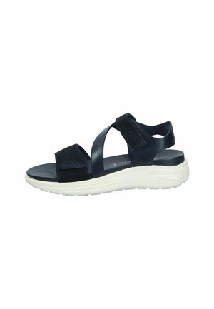 Black sandal featuring cross-strap design, suede and faux leather materials, cushioned white sole, and adjustable Velcro fasteners.