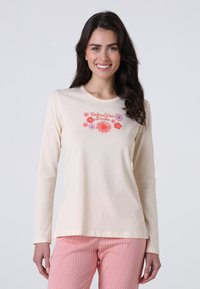 T-shirt a maniche lunghe beige chiaro realizzato in tessuto morbido, con un motivo floreale e la scritta "Abbraccia i tuoi sogni" in rosa e viola.