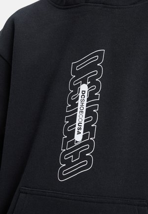 Black hoodie featuring a large white text graphic with "DCSHOE" and "DCSHOEUSA." Material appears soft with a smooth texture.