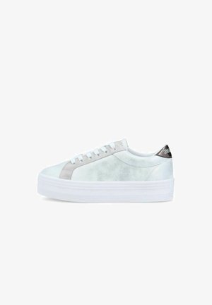 Zapatilla blanca de caña baja con suela gruesa tipo plataforma, cordones blancos, detalles en gris claro y lengüeta en el talón negra con branding blanco.