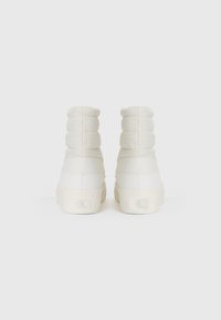 Hvite polstrede høyhælte sneakers med teksturert overflate, elastiske sidedele og logo detaljer på bakkappen. Glatt, stilren design.