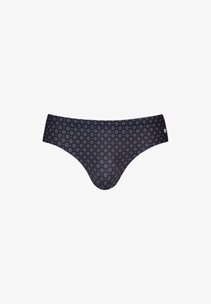 Marineblaue Badehose mit rundem Muster, kombiniert mit einem weißen Leinenhemd und schwarzen Sandalen. Glatter Stoff, figurbetontes Design und mittelhoher Bund.