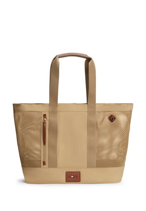 Beige taske med netpaneler på siderne, to brede håndtag, lynlåslomme foran og lille læderlogo i bunden midt på.