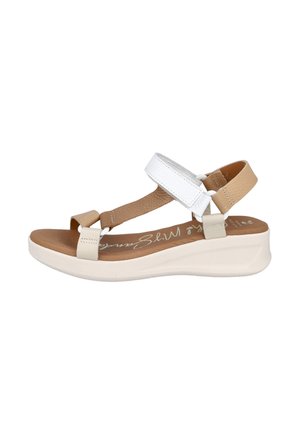Sandalia wedge beige y blanca con correas ajustables, parte superior texturizada y plantilla acolchada. Suela lisa de color claro.