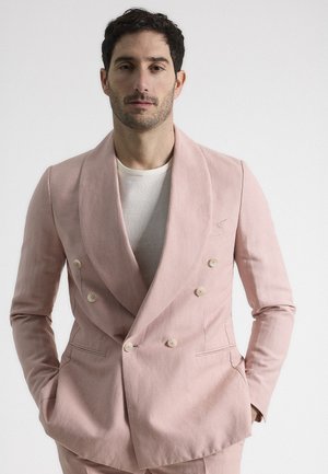 Blazer cruzado en lino rosa suave, con solapa tipo chal, dos bolsillos frontales y botones de color claro. Ajuste entallado con textura suave.