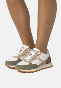 Mehrfarbige Sportschuhe mit weißem Mesh, beigem und grünem Wildleder sowie einem Leopardenmuster-Akzent. Gummisohle und gepolsterter Kragen.