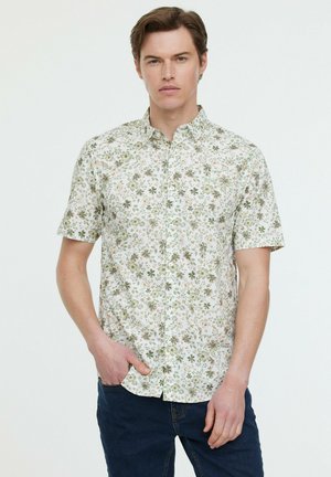 Chemise à manches courtes en tissu avec un fond blanc orné de motifs floraux verts et roses, dotée d'un col classique et de boutons.