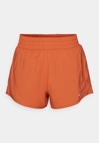 Pantalones cortos deportivos naranjas con cinturilla elástica, hechos de un material liviano. Presenta un pequeño logo blanco de Nike en la parte inferior izquierda.
