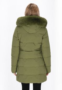 Olivengrøn pufferjakke med faux fur-krave. Har horisontalt quiltet design, elastiske manchetter og en hætte. Vist fra bagsiden.