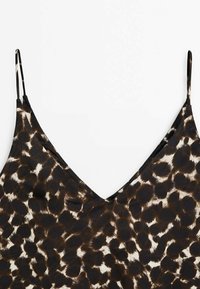 Leopard print cami top featuring a deep V-neck, adjustable thin straps, and a soft, lightweight fabric with a silky texture.