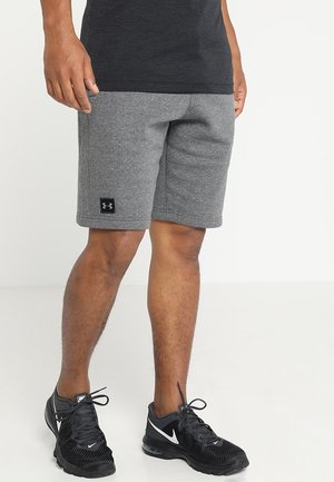 Graue Sportshorts aus weichem Stoff, mit einem schwarzen Logo am linken Saum, kombiniert mit schwarzen Laufschuhen mit weißen Akzenten.