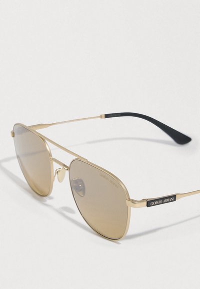 Γυαλιά ηλίου aviator με χρυσή κορνίζα, φακούς με καφετί απόχρωση και μαύρα άκρα στα κέρατα, με σήμανση Giorgio Armani στο πλαίσιο και στους φακούς.
