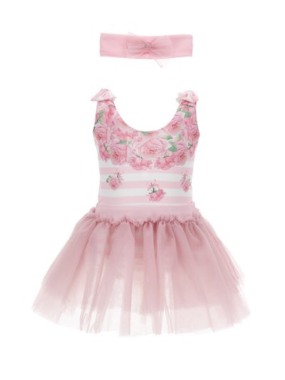 Vestido rosa con estampado floral y rayas horizontales, con una falda de tul y una diadema a juego con un lazo. El material es suave y ligero.
