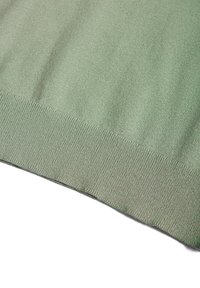 Pull en tricot vert avec une texture lisse, présentant un ourlet et des poignets côtelés. La couleur est uniforme, sans motifs ni accents visibles.