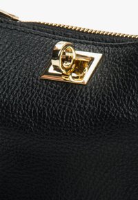 Zwarte leren tas met textuur, voorzien van gouden metalen details, een rechthoekig frame met een ronde ring en een gouden rits.