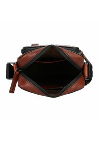 Borsa in pelle marrone con accenti neri, dotata di apertura con zip e un ampio interno. Presenta cuciture robuste e una tracolla staccabile.