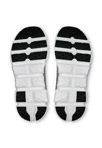 Semelles de chaussures de sport en noir et blanc, présentant une surface texturée, un design segmenté et des motifs hexagonaux pour l'adhérence et le soutien.