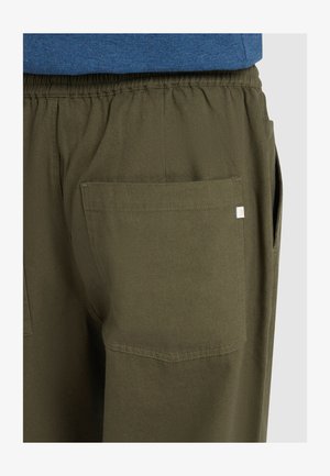 Olivgrüne Hose mit lockerer Passform, elastischem Bund und großer Gesäßtasche. Der Stoff wirkt weich und hat eine glatte Textur.