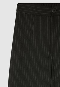 Czarne spodnie w paski z fakturowanej tkaniny, gładkim pasem w talii oraz pojedynczym zapięciem na guzik. Paski w kontrastowym jasnym kolorze.