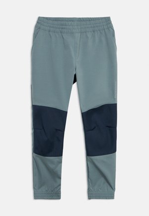 Bērnu elastīgās jostasvietas sporta bikses gaiši pelēkā krāsā ar tumši pelēkiem plāksteriem ceļgalos un elastīgām aprocēm, attēlotas guļus uz balta fona.