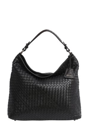 Sac à main en cuir noir tissé avec une sangle unique et une petite étiquette attachée près du bord de la poignée.