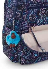 Zaino blu navy con vivaci motivi floreali in blu e rosa. Include un portachiavi a forma di gorilla peloso blu attaccato alla cerniera.