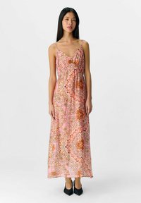 Largo vestido rosa con intrincados patrones florales en naranja y dorado, fabricado con un tejido ligero, diseño con escote en V y tirantes ajustables.