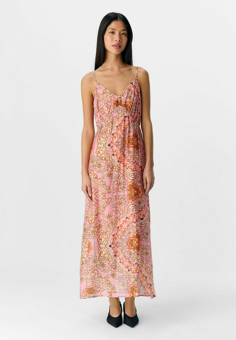 Largo vestido rosa con intrincados patrones florales en naranja y dorado, fabricado con un tejido ligero, diseño con escote en V y tirantes ajustables.