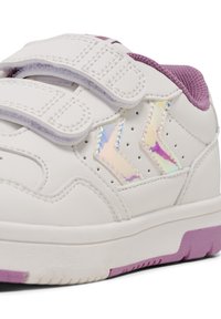 Białe sneakersy z rzepami, fioletowymi akcentami i irydyscencyjnymi detalami po bokach. Projekt wyróżnia się perforacjami oraz teksturowaną podeszwą.